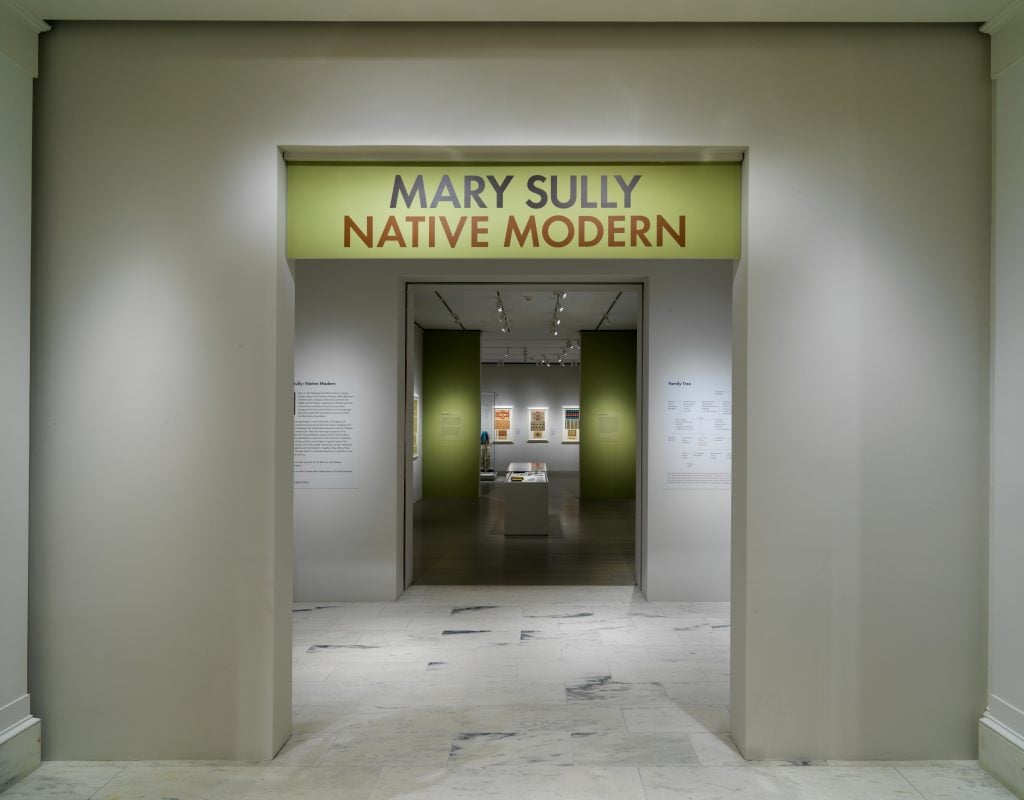 "Mary Sully: Native Modern" at the Metropolitan Museum of Art, New York. The photo shows a series of doorways at the entrance to the exhibition, with the show's name on a light green sign above the entrace. 