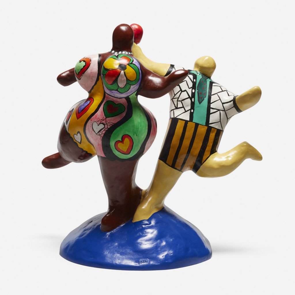 Post-war and contemporary art lot by Niki de Saint Phalle showing two intricately decorated figures dancing on a blue base.