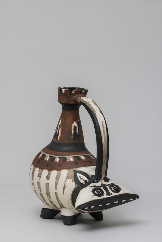 A ceramic vessel in the shape of a stylized hippo in brown white and black glaze by Pablo Picasso.