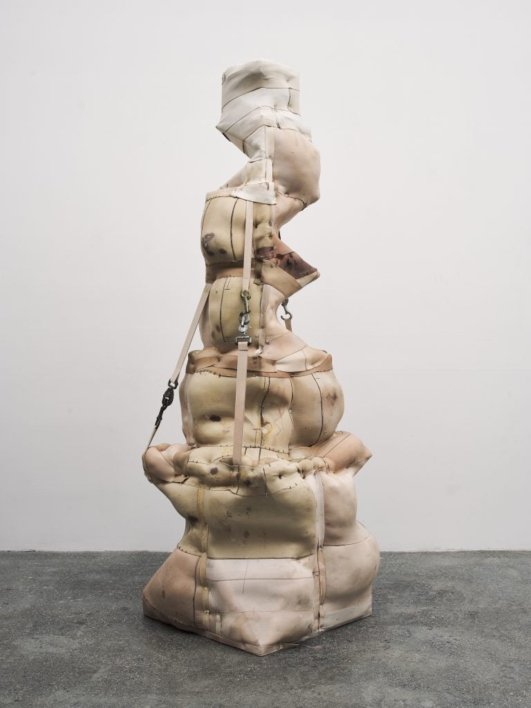 Sculptural assemblage by Patricia Ayers made from canvas fabric and straps, stuffed upright.