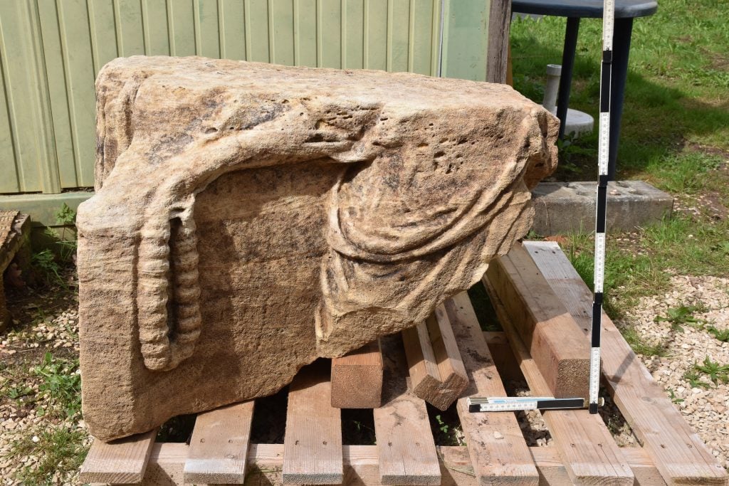 fragment of the votive monument sits on a pallet