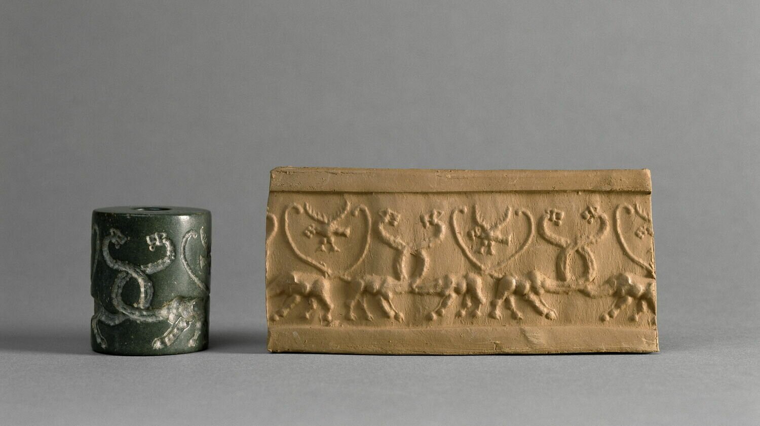 A photograph of a cylinder seal with a pattern embossed into it, and a yellow piece of clay to the right bearing its stamp, all on a gray background.