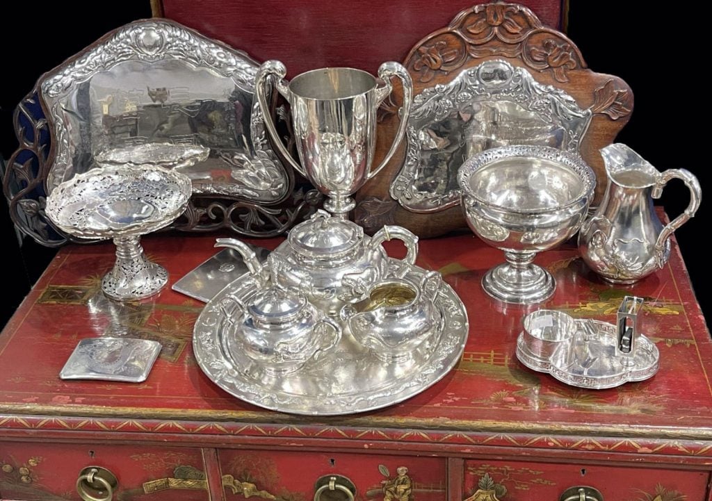 Various items of silverware against a red table surface.