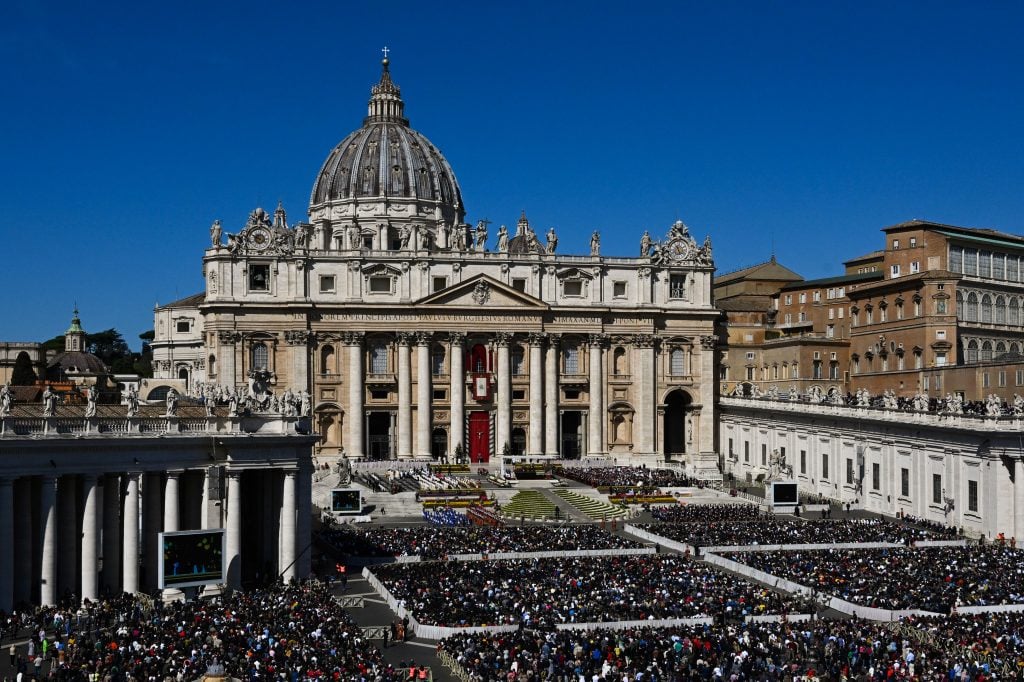 An exterior view of St. Peter's basilica with its square crowded by a mass of people