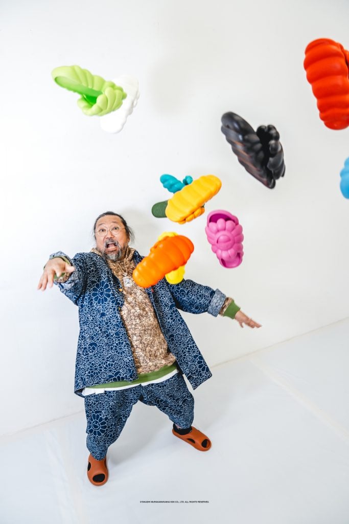 Takashi Murakami tossing a handful of rubber shoes in the air