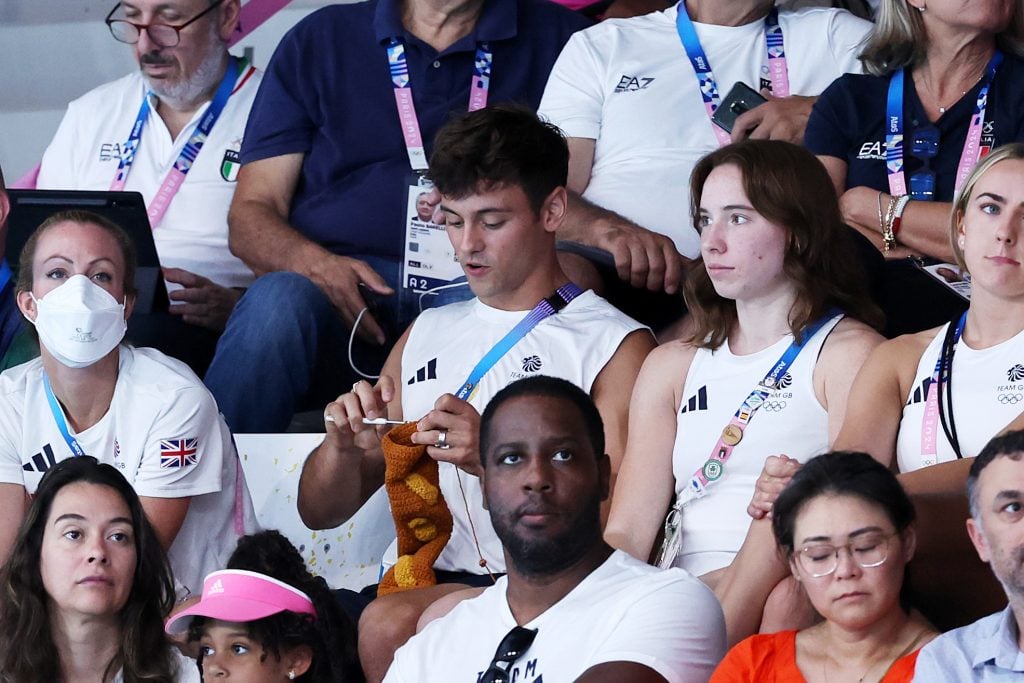 Tom Daley of Team Great Britain is seen knitting during the Men's Synchronized 3m Springboard Final on day seven of the 2024 Paris Olympic Games.