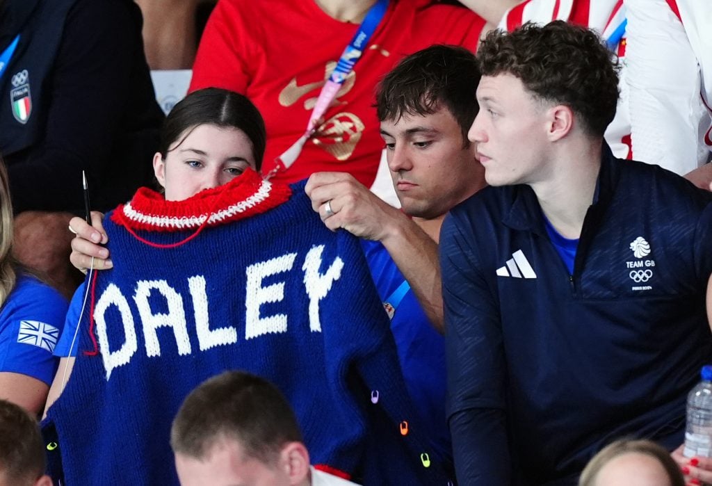 Great Britain's Tom Daley knitting as he watches the Women's Synchronised 3m Springboard Final at the Aquatics Centre on the first day of the 2024 Paris Olympic Games in France.