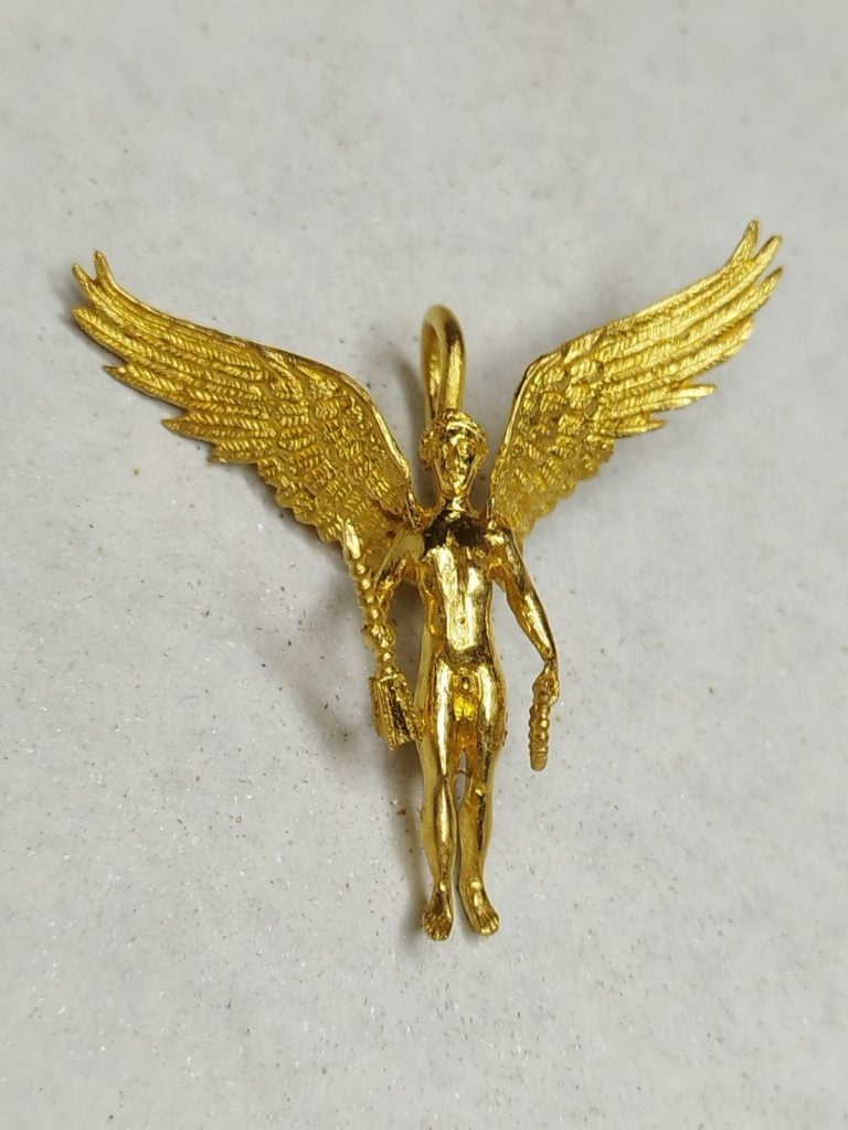 An ancient gold figurine showing a deity with outspread wings