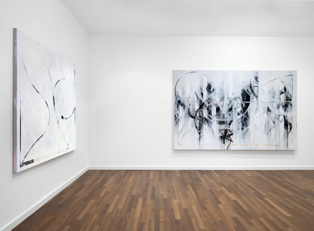 Ruscha Voormann black and white abstract paintings hang in a gallery