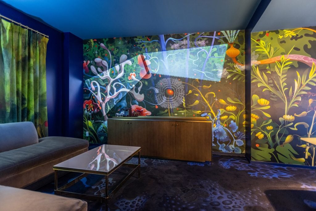 a hotel room is lit with neon lights and has a jungle scene 