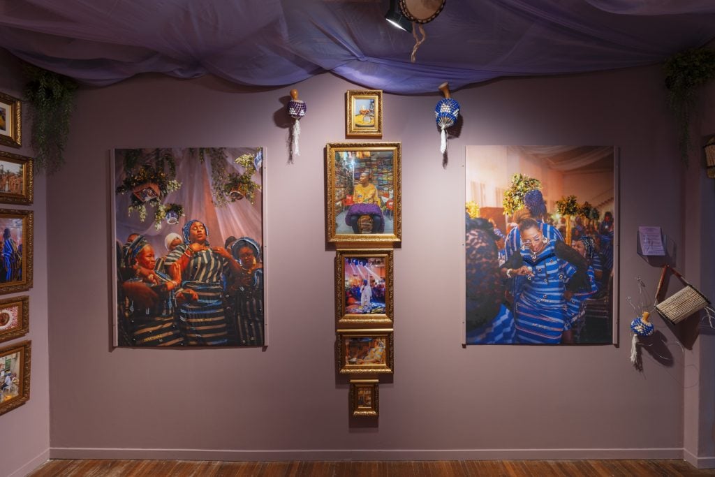 Installation view of a series of paintings in the middle, and two colourful paintings on the side