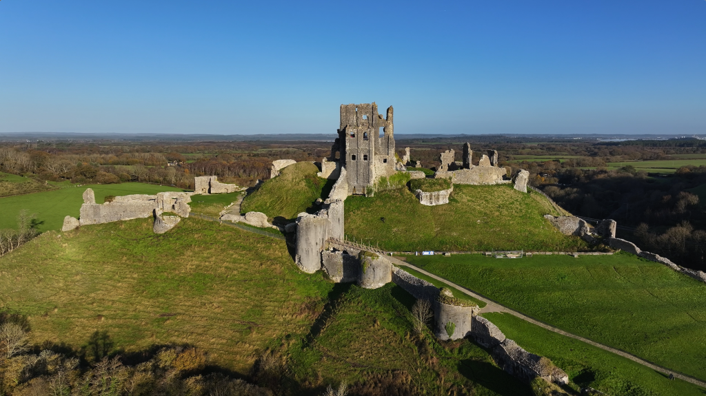 a view of a castle in a green rolling hill