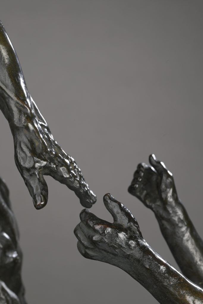 a close up of two bronze hands from a sculpture