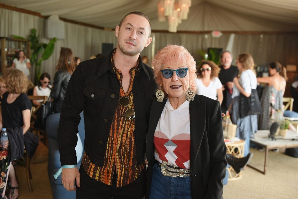 a white man and woman wearing sunglasses stand next to each other