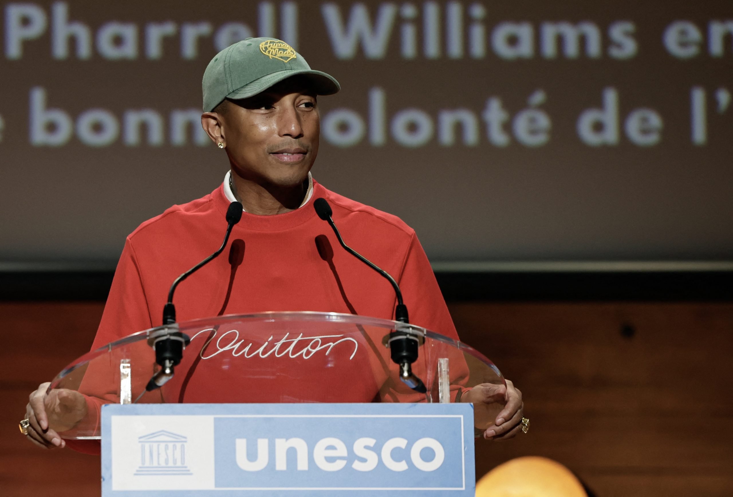 Pharrell Williams on stage in a red sweater