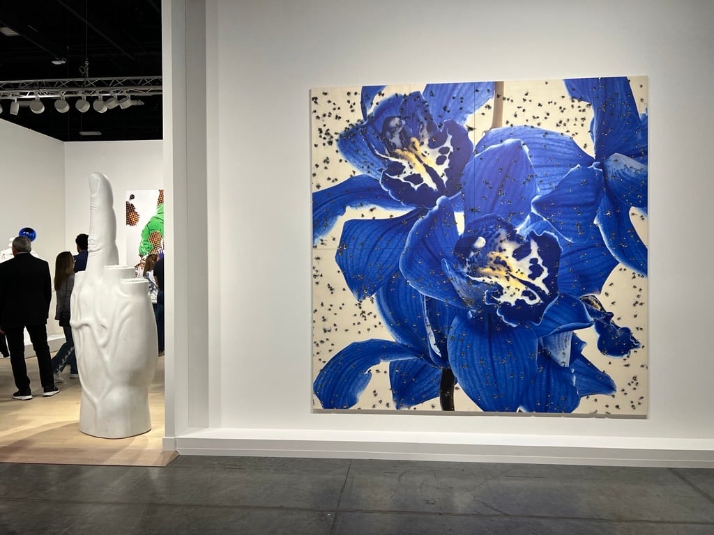 a sculpture in the shape of the middle finger and a painting of a blue flower