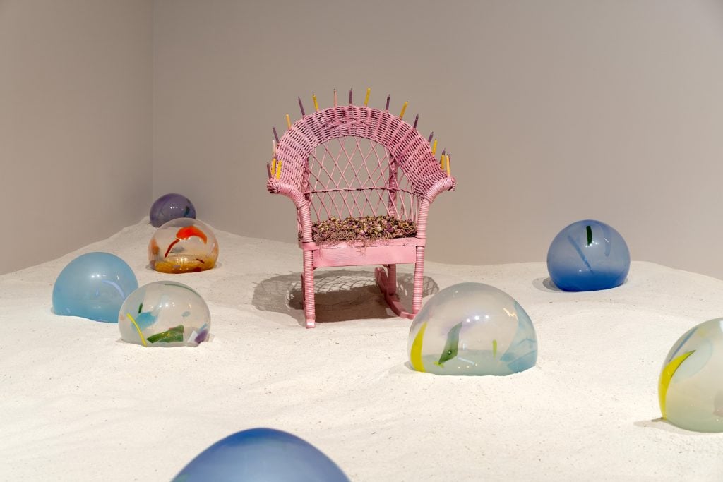 a gallery is filled iweth what looks like large marbles and outdoor furniture 