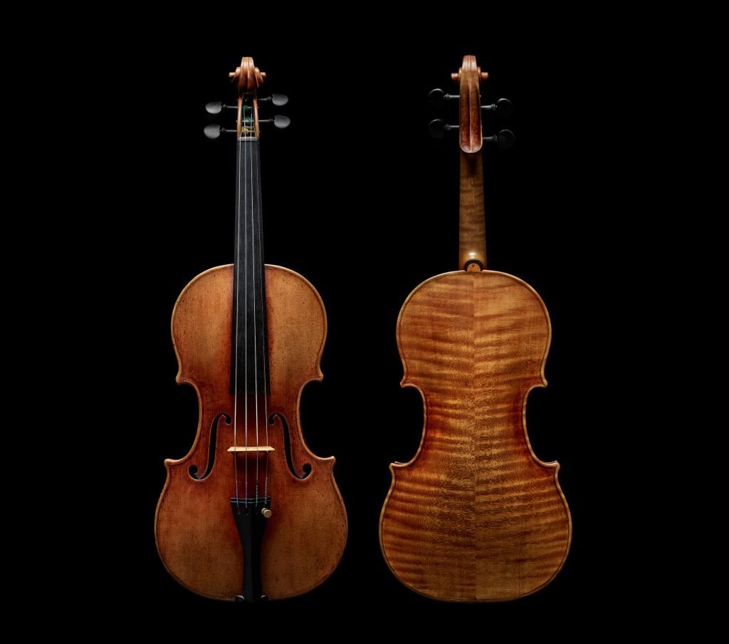 the back and front of a violin on a black background