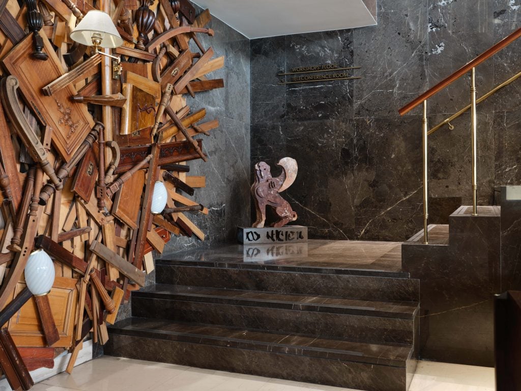 a sphinx and a wooden swirl adorn a wall in a luxury hotel 