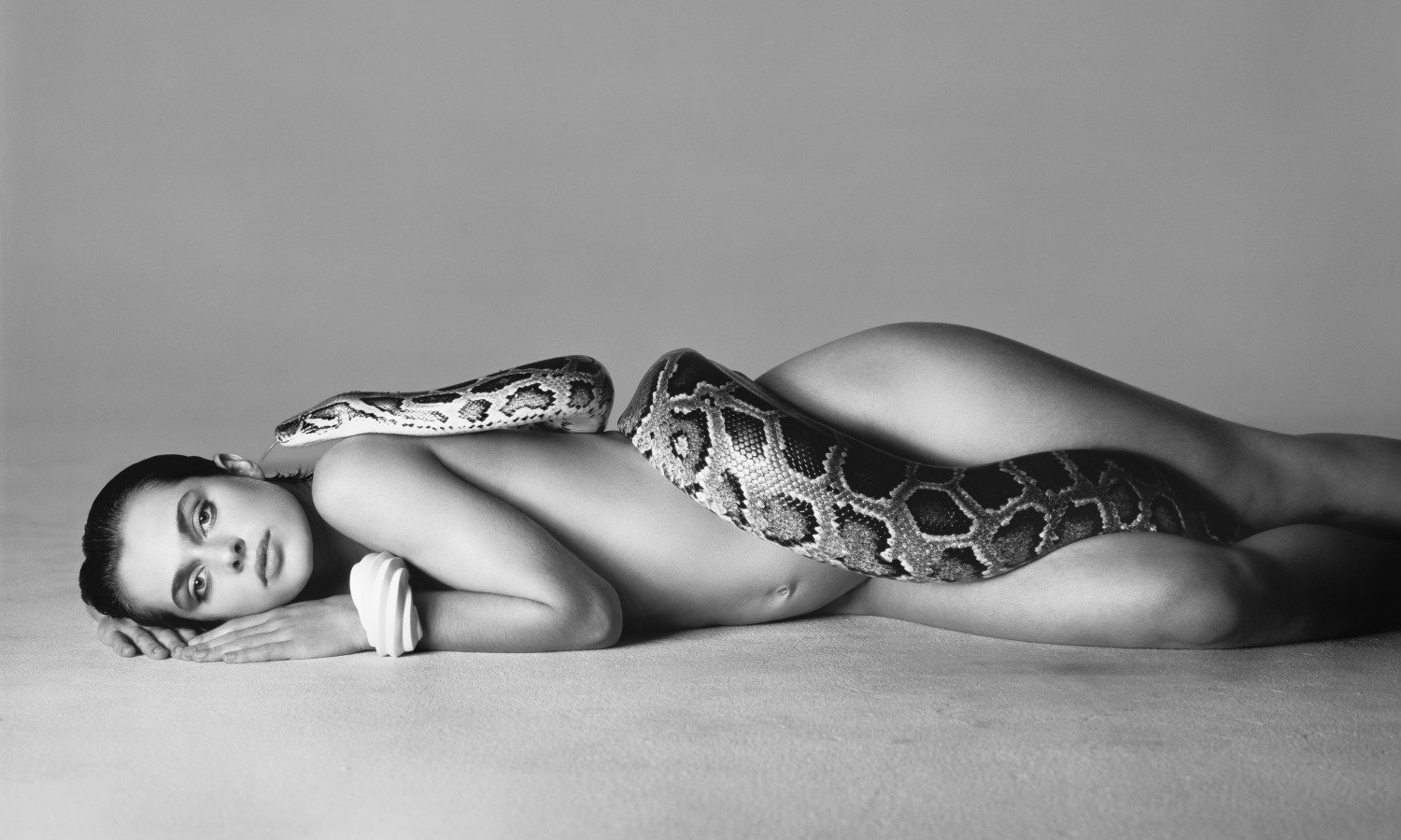 Richard Avedon photograph of a naked model lying on the floor, entwined with a snake