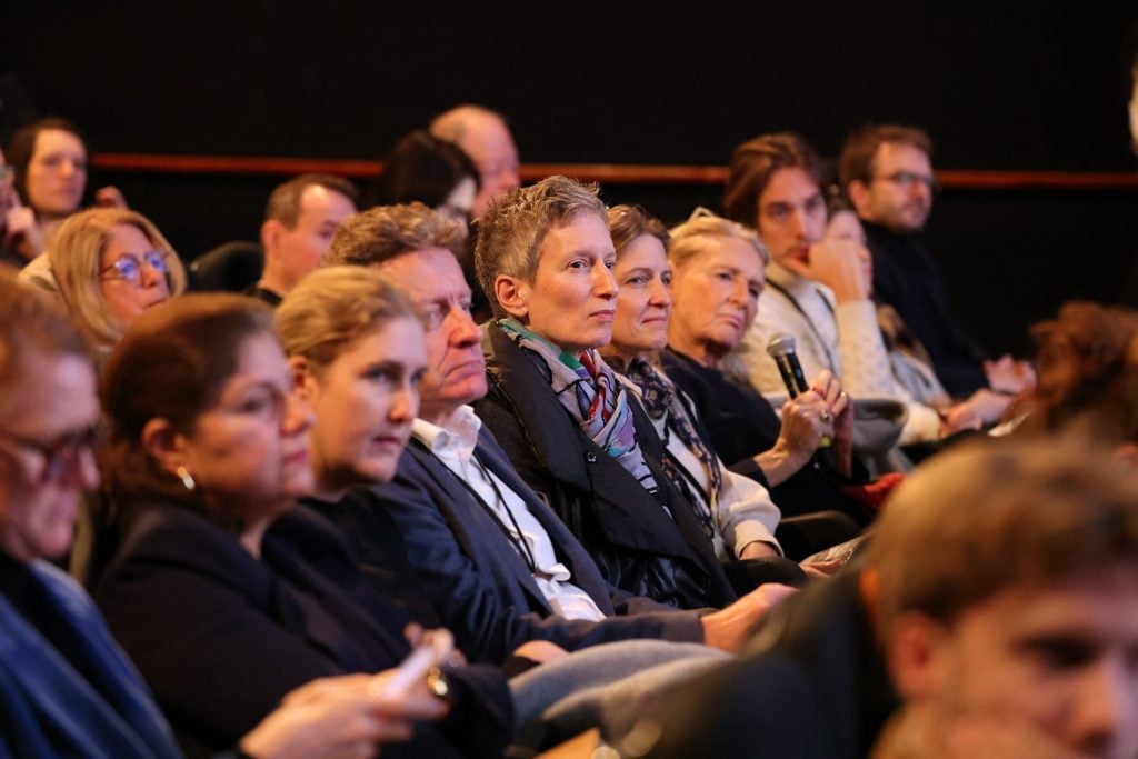 a crowd of people sitting in a large room 