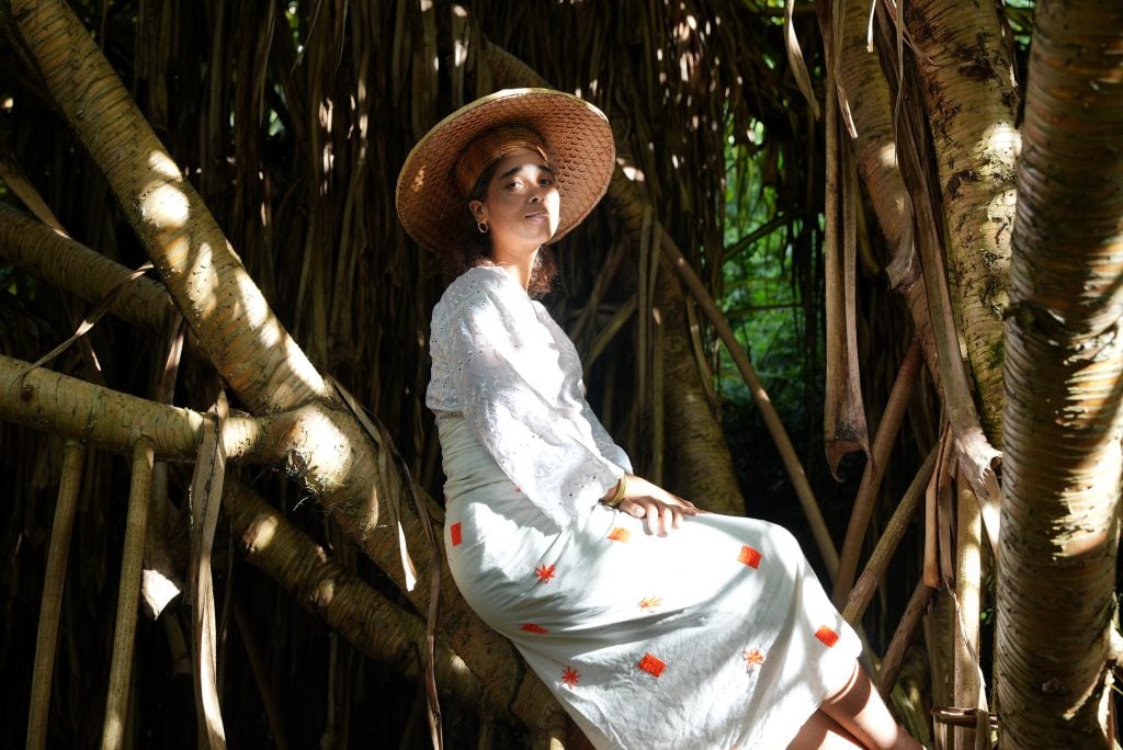 a woman in a hat on a tree branch