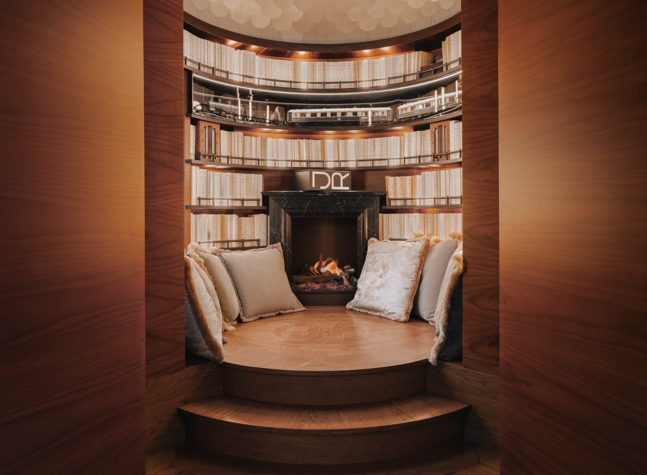 a train car has a circular luxurious library with a wooden floor