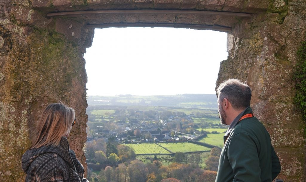 a view through a stone window looking out over the English countryside