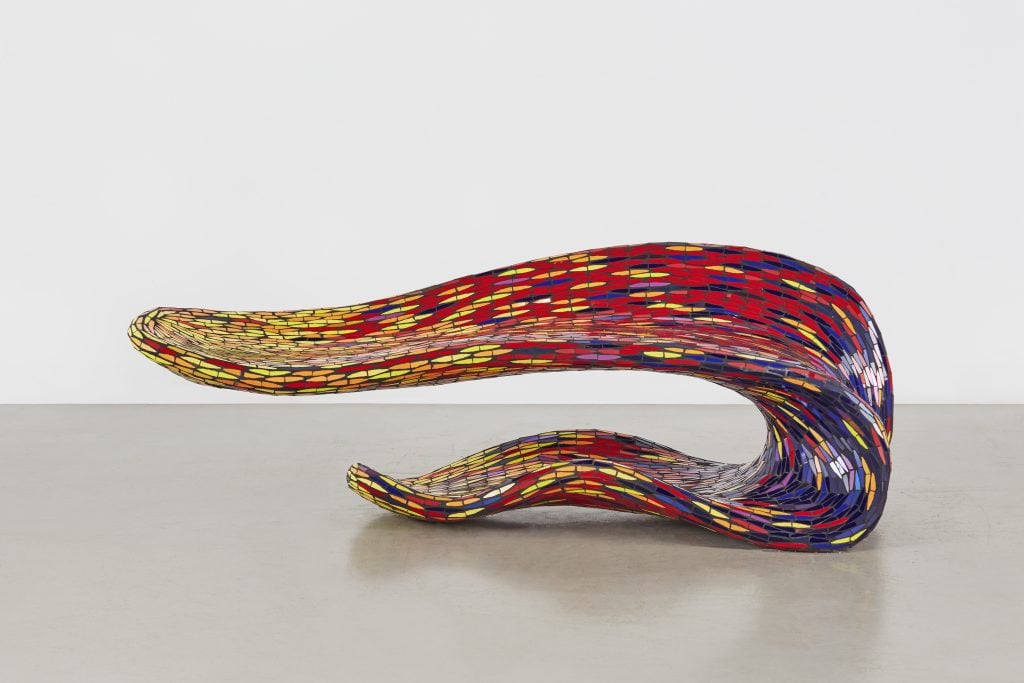 a piece of furniture looks like an undulating tongue of stained glass 