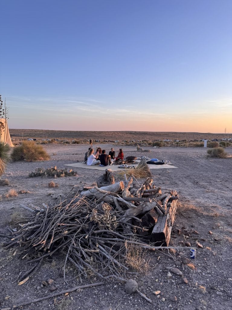 in the desert a group relaxes on a mat 