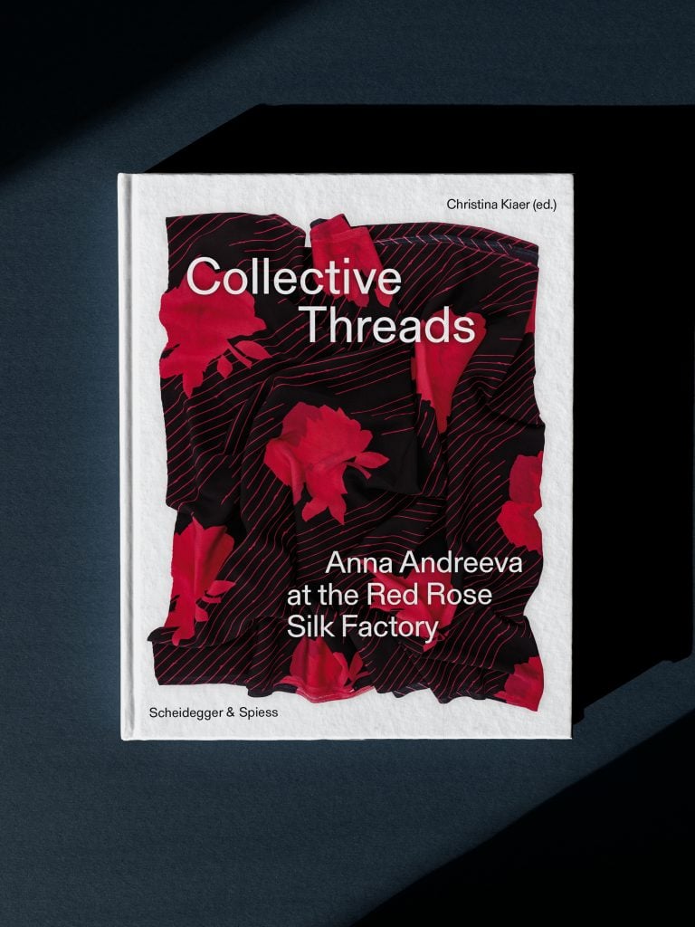 Cover of the exhibition catalogue "Collective Threads: Anna Andreeva at the Red Rose Silk Factory" featuring an example of one of the artists marron and red floral textiles.