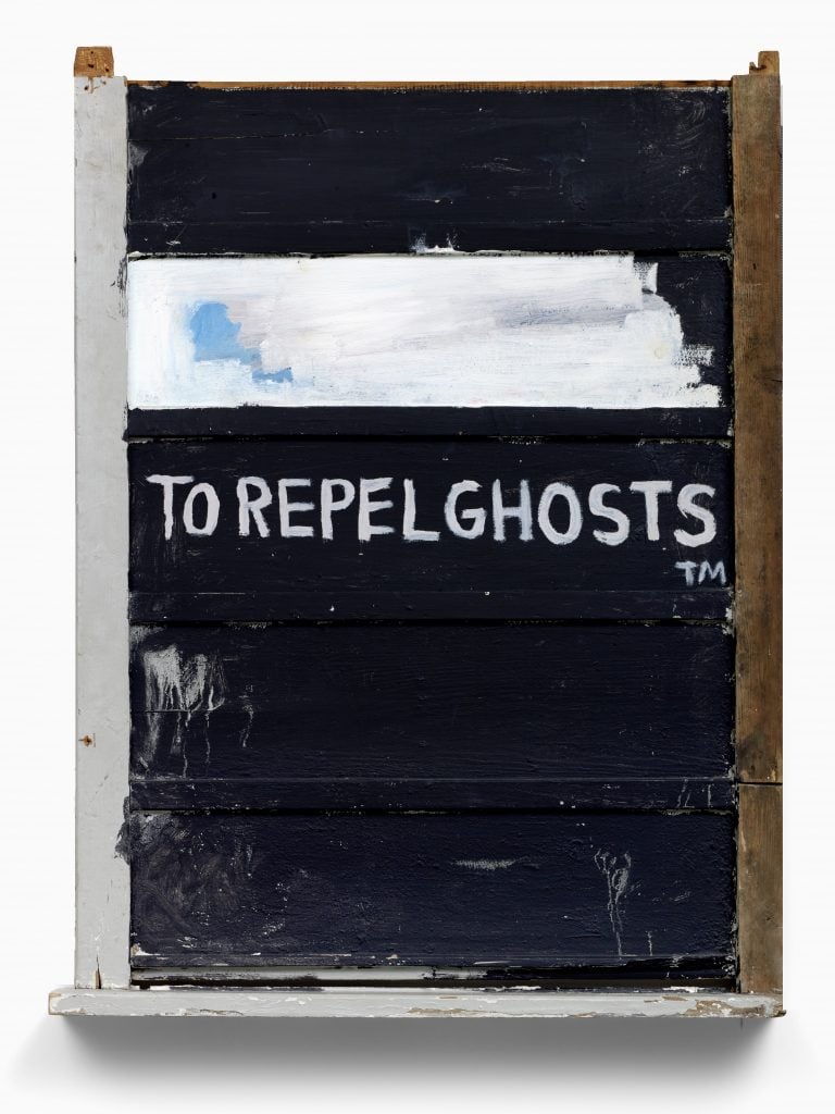 A photograph of a portrait-orientation painting depicting the words 'torepelghosts(tm)' on an all black background, with a rectangle of white above it.