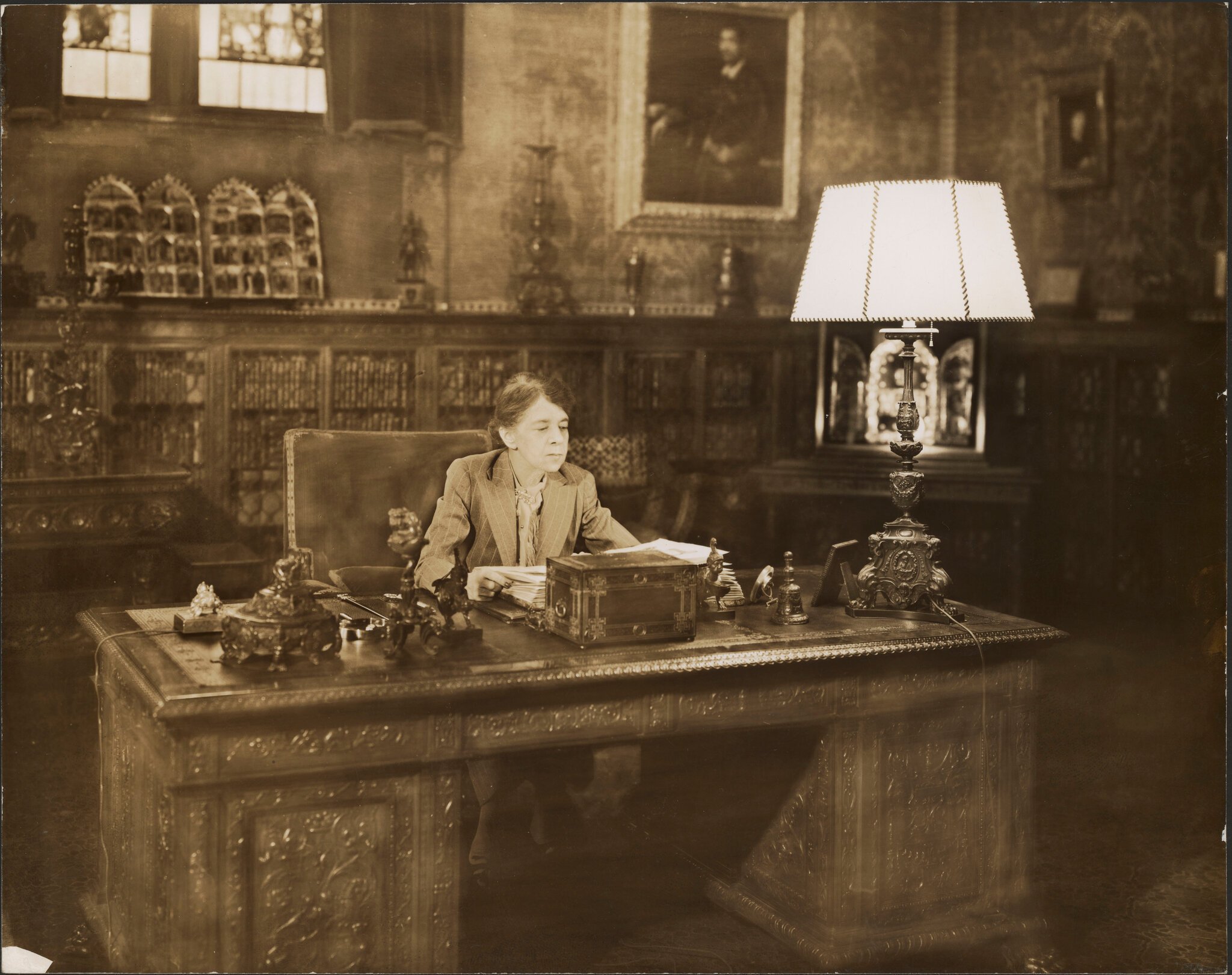 A woman sitting at a large desk in a library