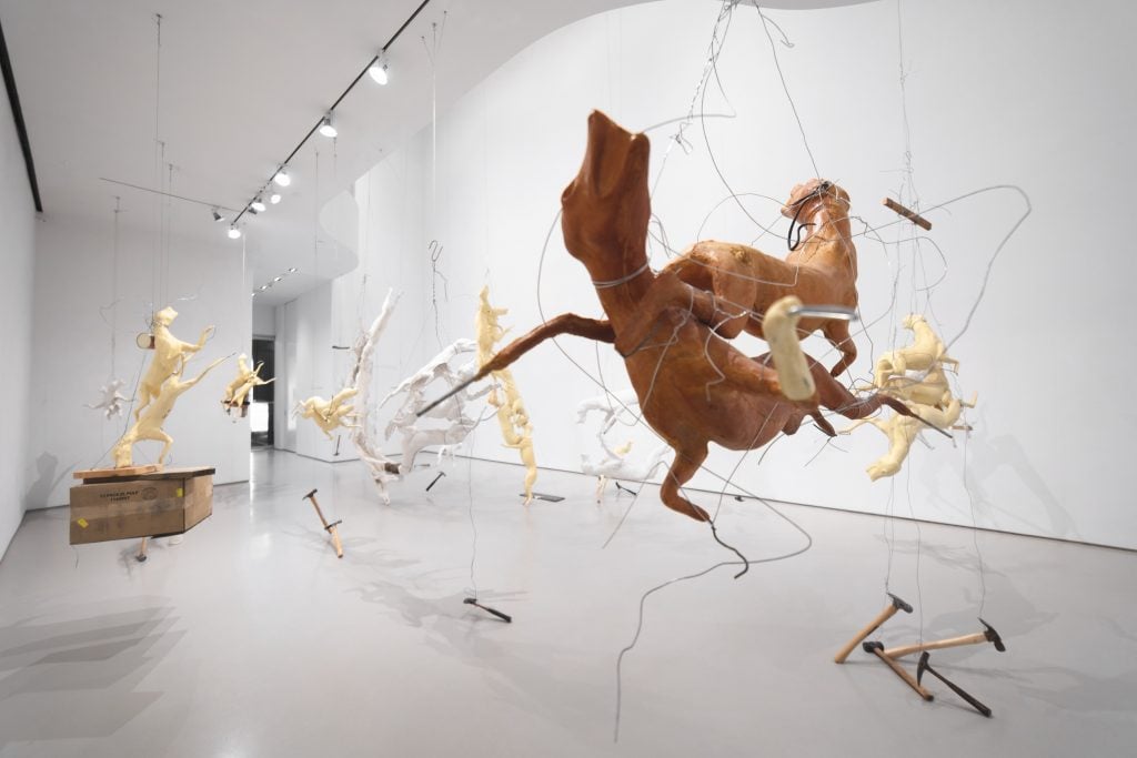 An art gallery with a number of hanging sculptures made from fox and coyote taxidermy forms