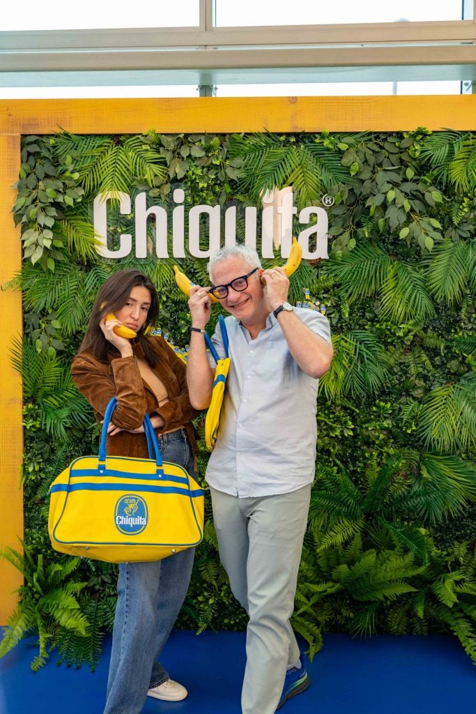 Fairgoers pose for photos with bananas and the coveted Chiquita bag at the Chiquita banana stand at Art Basel Miami Beach.