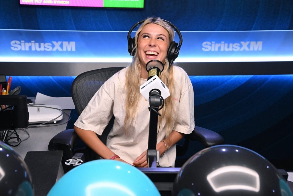 A woman at a microphone in a podcasting studio