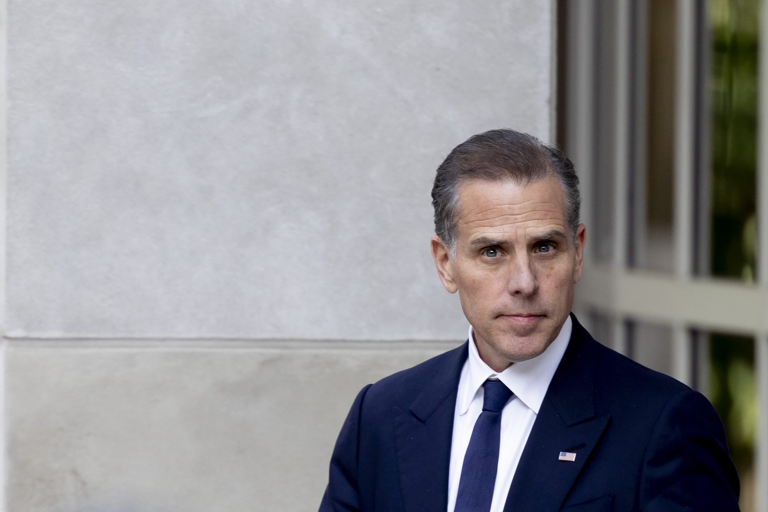 Hunter Biden in a suit standing outside a courtroom