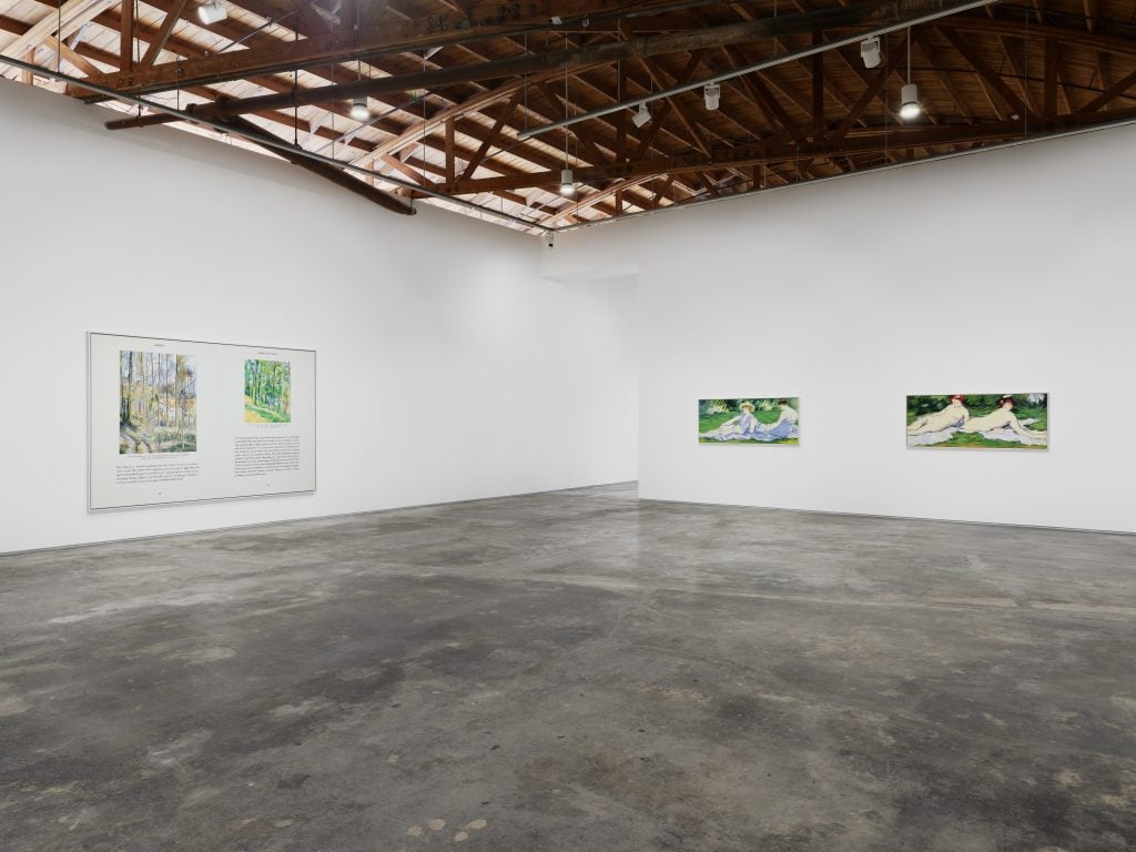 Installation view of the solo show at night gallery "Cynthia Daignault: The Lemon" showing three paintings in a white wall gallery space under a raw wooden tressel 