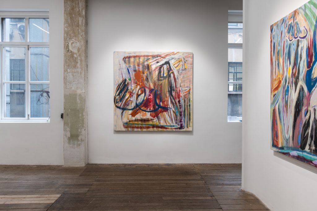 Installation view of "Diana Motta: Heaven Touched" solo show in the gallery's Shanghai space, with a square abstract painting installed on the gallery wall flanked by two antique windows.