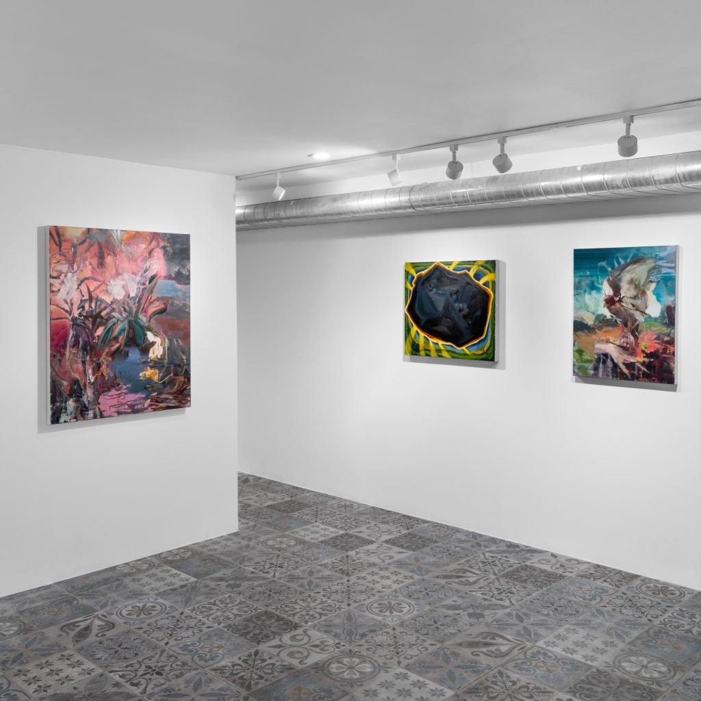 Installation view of "Tomorrow Takes Care" featuring the work of Martin Golland and Atticus Gordon, each having paintings on a windowless, carpeted white gallery room space at Ivory Gate in Shanghai.