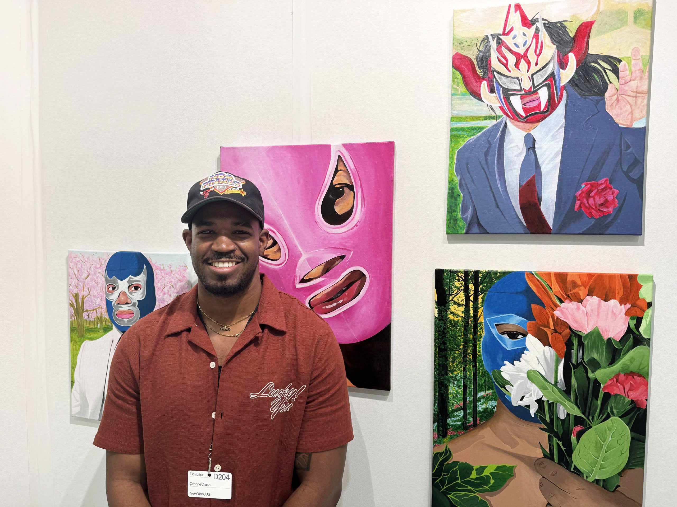 A man standing in front of paintings of wrestlers