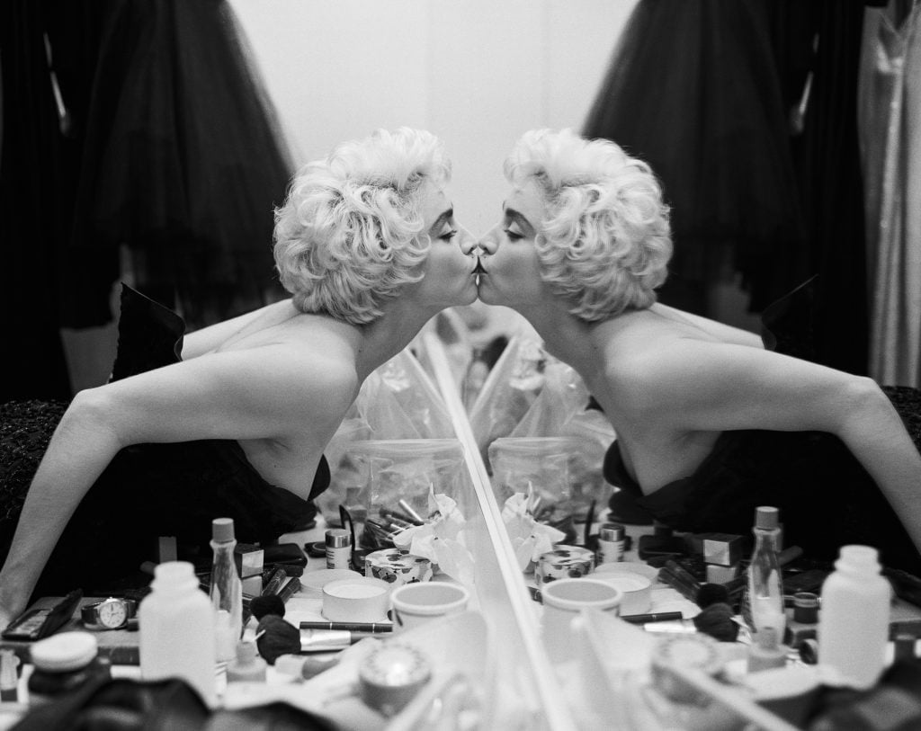 Bruce Weber photograph of Madonna leaning in to kiss her reflection in a mirror