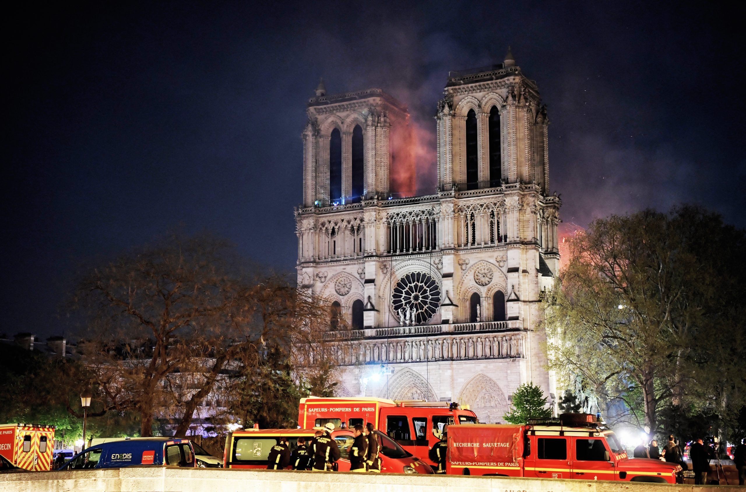 An image of firefighters gather outside Notre-Dame Cathedral in Paris on April 15, 2019, after fire engulfed the building.