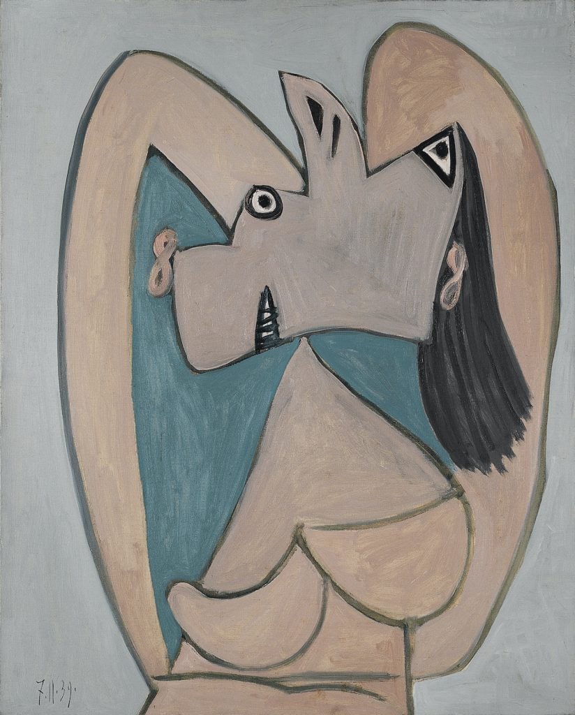 A Pablo Picasso painting of a woman with her arms crossed behind her head