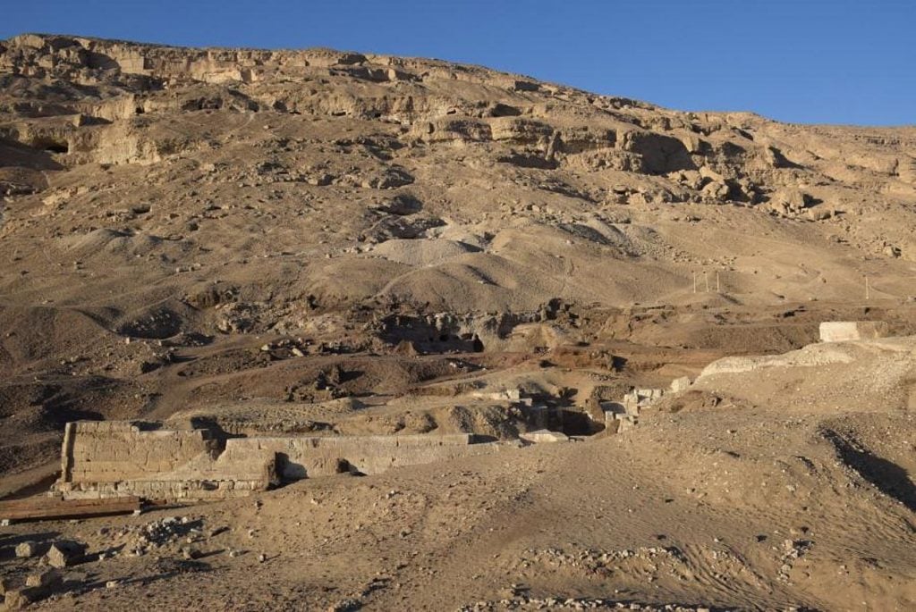 a desert scene with a hill in the background