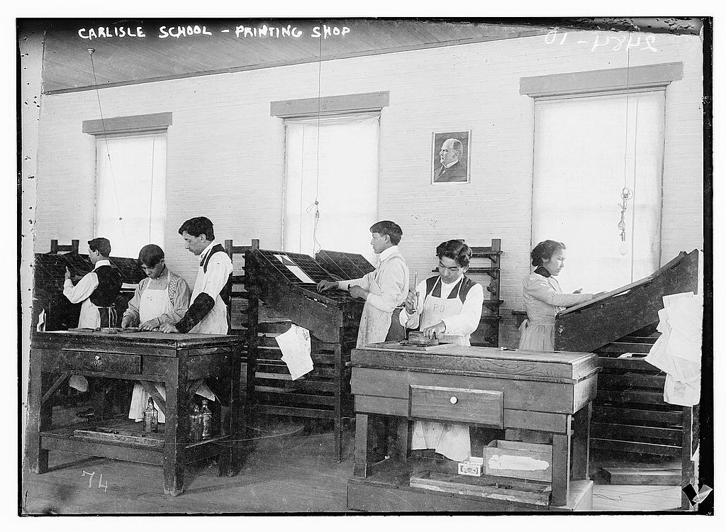 Children are seen working in a printing shop at the Carlisle School is seen in a 1910-1915 photograph by the Bain News Service