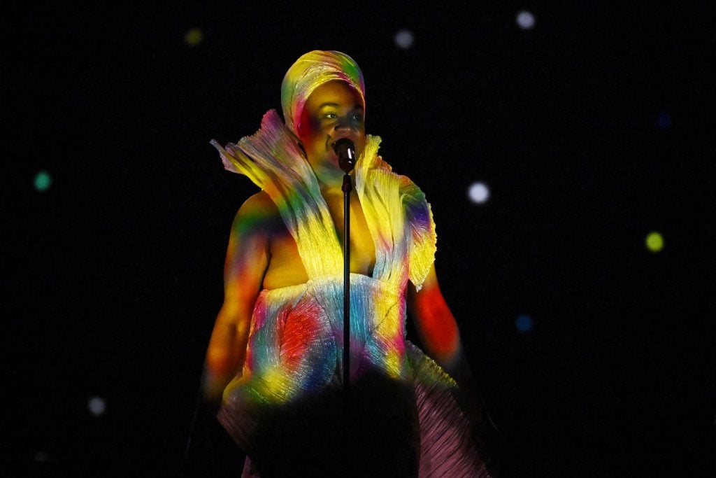 Zaachariaha Fielding performing onstage in a rainbow colored outfit