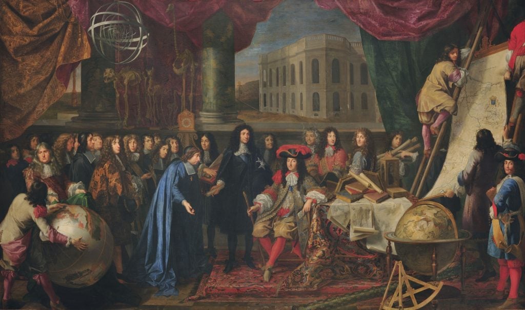 an old fashioned painting in which a large group of well dressed men assemble and arond them are old fashioned instruments for scientific study like globes or skeletons