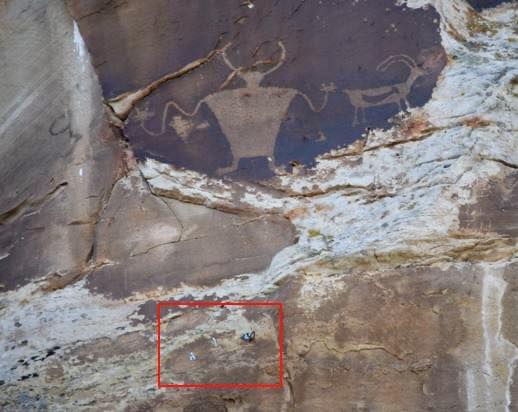 A red bounding box inserted into an image highlights the location of the climbing bolts near ancient petroglyphs