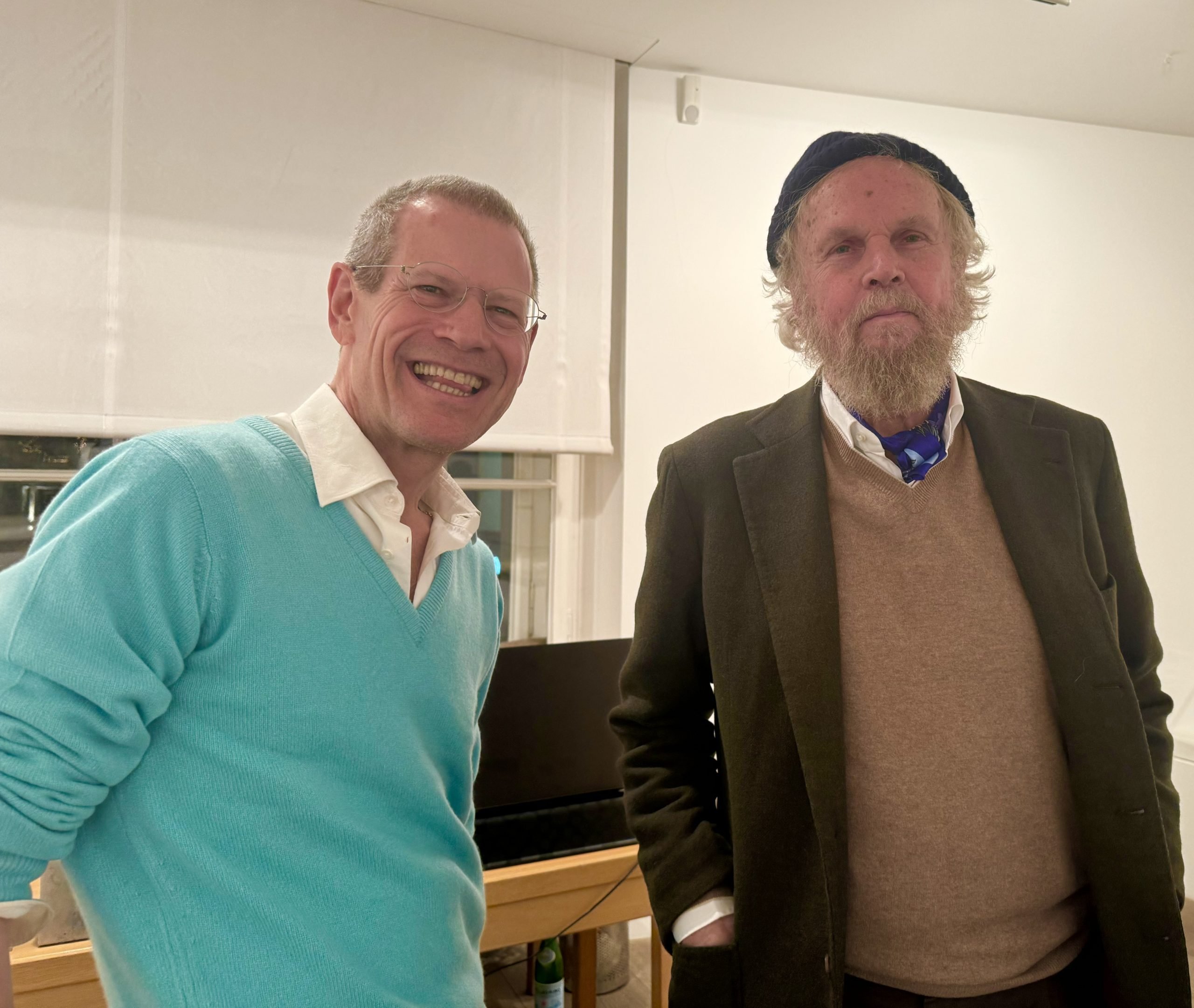 Two men in sweaters pose for a photo